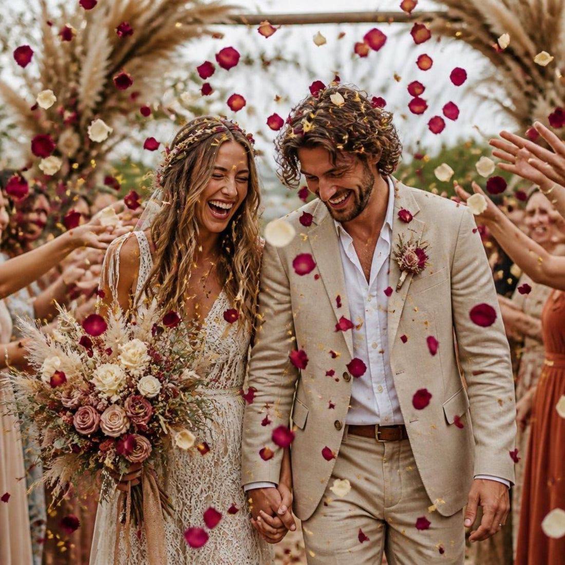 Newlywed couple walking beneath an archway while guests shower them with colourful dried flower confetti