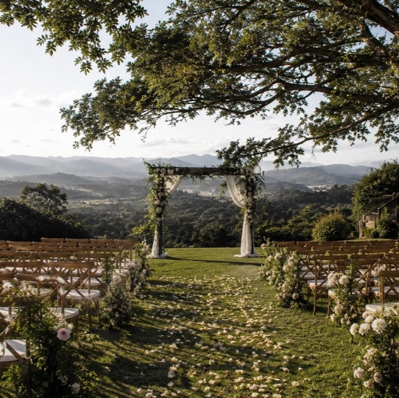 Confetti on ground at an outdoor ceremony. Hills in the background. 
