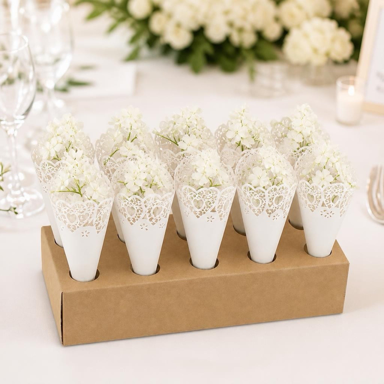 White lace cones filled with flowers on a cardboard stand.