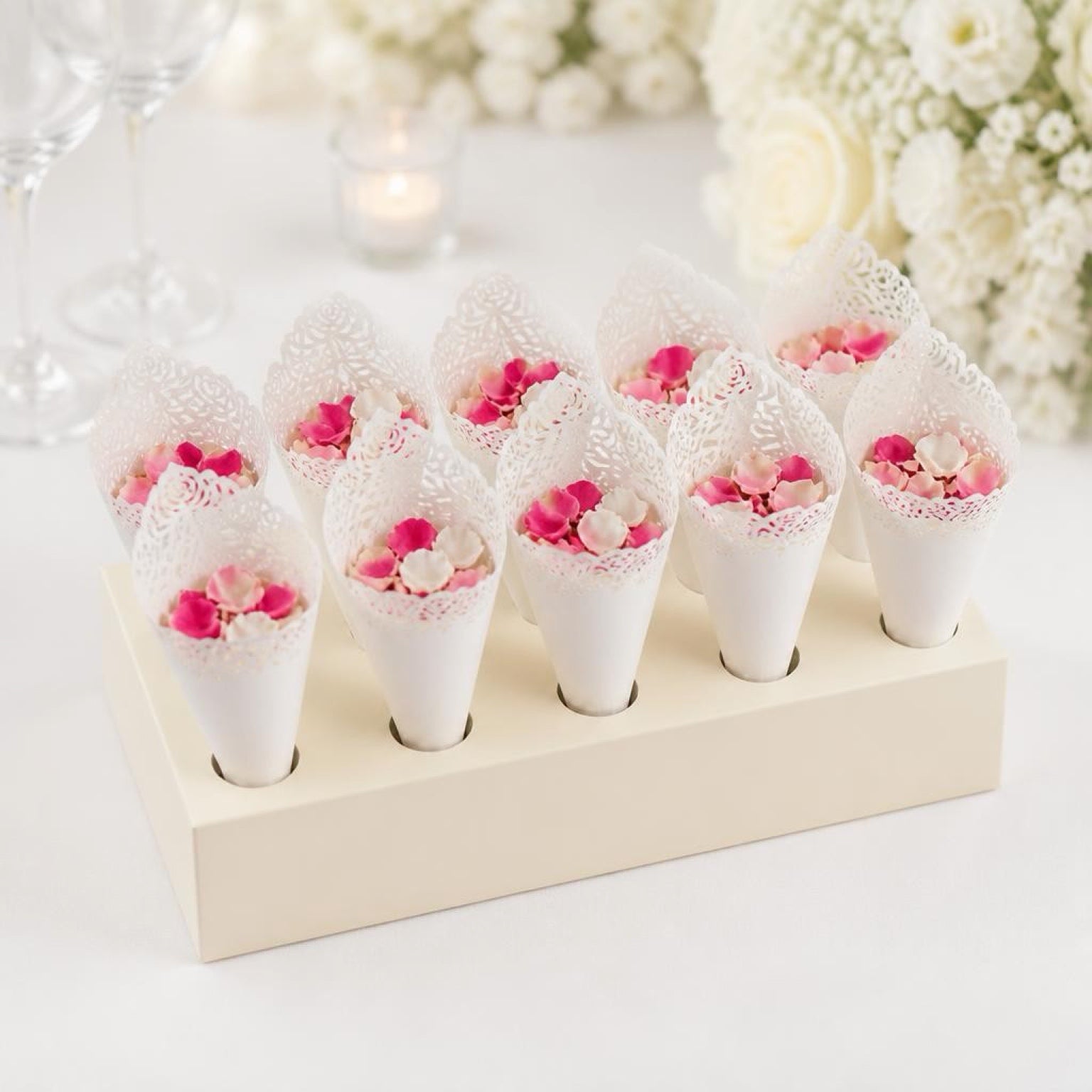 Decorative cones with pink flowers on a white stand against a floral background